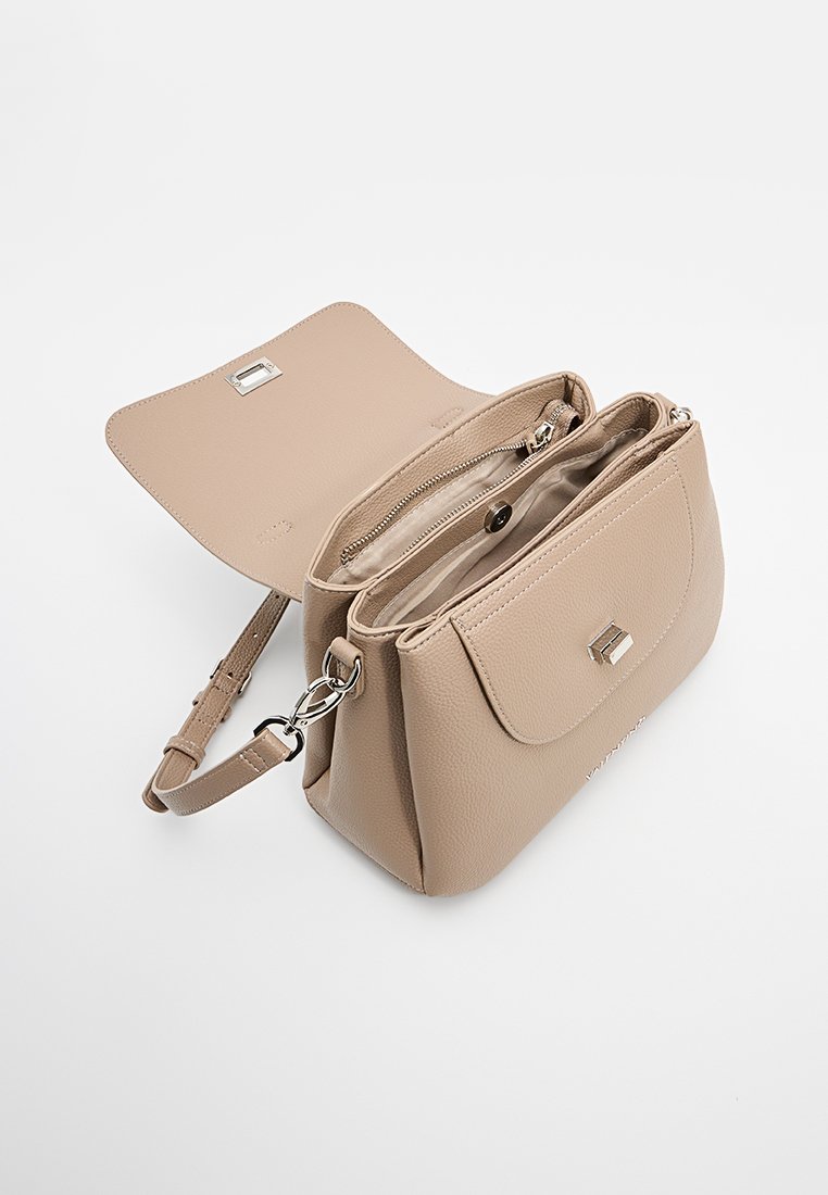 Sac à main en cuir beige avec une fermeture à rabat, quincaillerie en argent, compartiments à double zip et une bandoulière réglable. Détail de surface texturé.