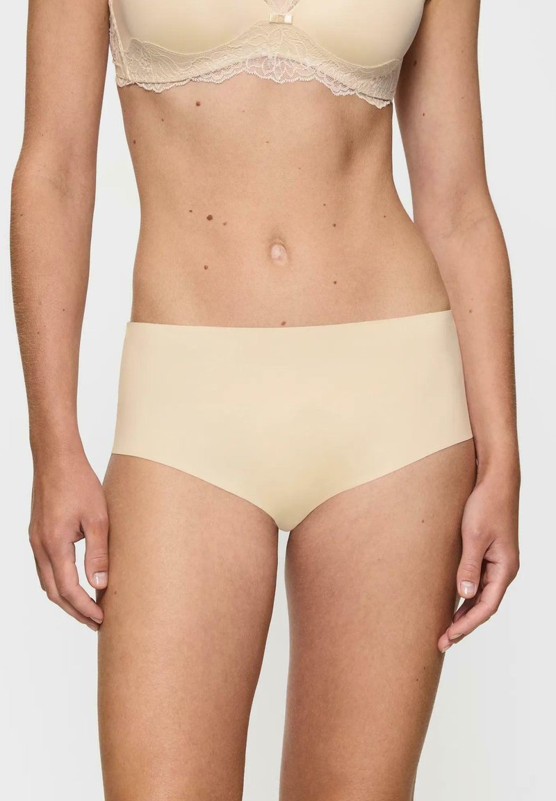 Beżowe bezszwowe figi hipster wykonane z gładkiego materiału, o średnim stanie, oferujące minimalisticzny design i wygodne dopasowanie.