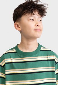 Striped t-shirt in green, featuring horizontal stripes in black, beige, and yellow. Round neckline with a relaxed fit, made of soft cotton.
