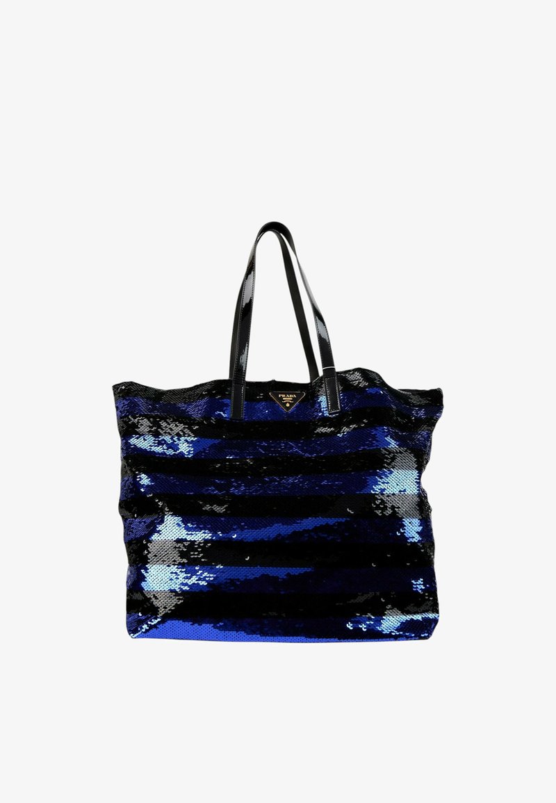 Grand sac cabas avec des rayures horizontales brillantes noires et bleues, des poignées noires brillantes et un petit logo Prada triangulaire en haut au centre.