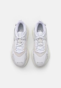 Vita sneakers med texturera tyg, vadderad tunga och tonade accenter. Snörad design och en tjock gummisula för ökat grepp.