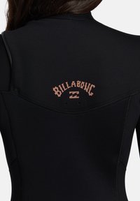 Mutino nero con scollatura curva e logo rosa sul retro. Texture liscia con cuciture rinforzate lungo le cuciture.