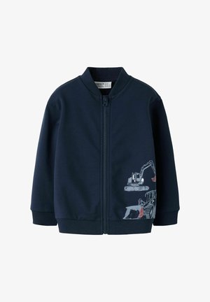 Jūras zila zipa jaka, kas izgatavota no gludas auduma. Uz apakšējās priekšpuses ir būvtransporta grafika. Ribota apkakle un piedurknes.