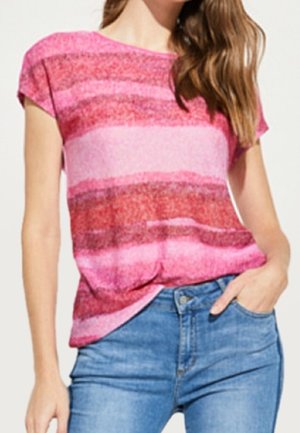 Frau trägt einen kurzärmligen rosa und roten gestreiften Pullover, der leicht in die hoch taillierte blaue Jeans gesteckt ist, mit der Hand in der Tasche.