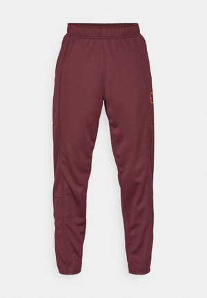 Pantaloni de trening bordeaux fabricati dintr-un material moale, cu talie elastica, picioare conice si buzunare laterale. Prezinta un patch cu logo pe sold.