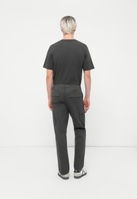 Tricou gri cu mânecă scurtă, asortat cu pantaloni cargo gri, care au buzunare laterale, etichetă pe talie și un design front flat. Textură moale și croială lejeră.