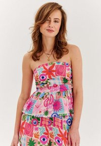 Sukienka bez ramiączek w stylu peplum z kwiatowym wzorem w kolorach różowym, zielonym i niebieskim. Posiada teksturowany, lekki materiał oraz podkreśloną talię.