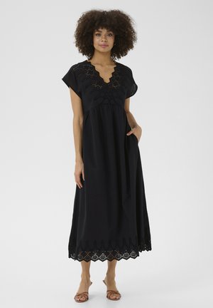 Black dress with short sleeves, V-neck, and intricate eyelet detailing along the bodice and hem, featuring a flowy silhouette and pockets.