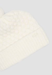 Witte gebreide beanie met een textuur, verhoogd patroon en geribbelde manchet. Voorzien van een klein, discreet label aan de zijkant. Zacht, dik materiaal.