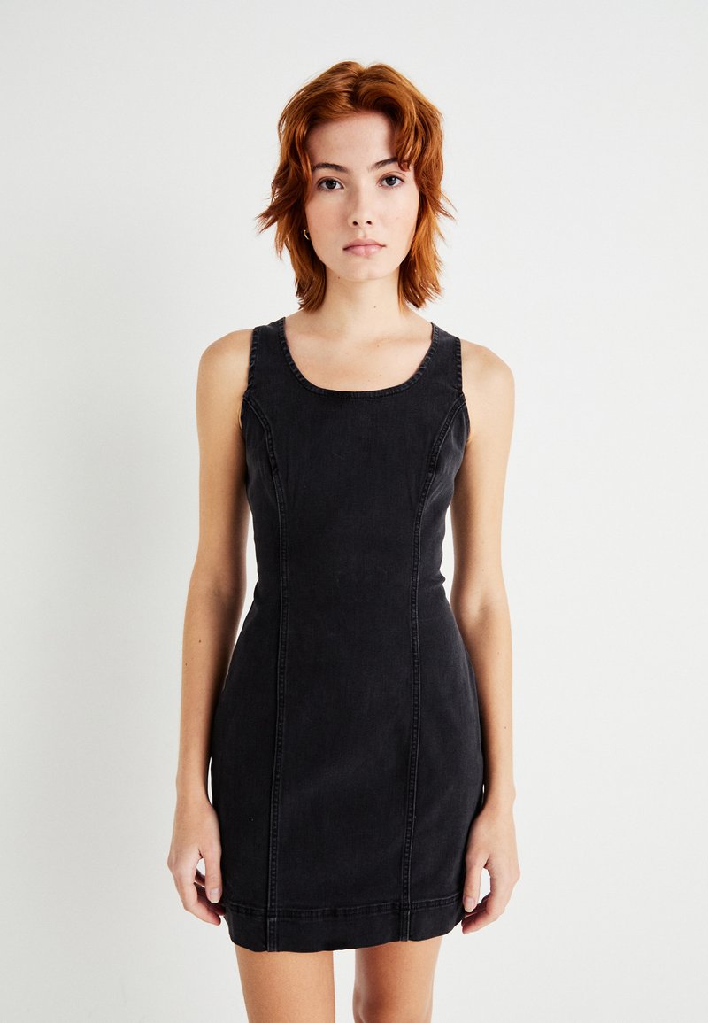 Μαύρη τζιν φόρεμα με εφαρμοστή γραμμή, φαρδιά μανίκια και τετράγωνη λαιμόκοψη. Διαθέτει ορατές ραφές και στρίφωμα που τελειώνει στο μέσο του μηρού.