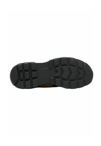 Suela de zapato de goma negra con un patrón de huellas profundo, superficie texturizada y ranuras definidas para tracción y estabilidad.