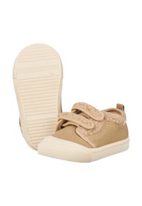 Beige Canvas-Schuhe mit einem flauschigen Zehenbereich, Klettverschlüssen und einer strukturierten weißen Gummisohle. Leichtes Design mit abgerundeter Form.