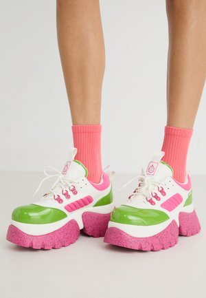 Paksud tossud, millel on läikiv roheline ja valge pealispind, roosad aktsendid ning tekstureeritud roosa täpikate tald. Kanda koos erksate roosade sokkidega.