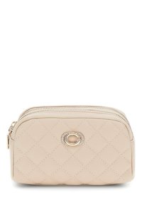 Borsa cosmetica beige trapuntata con logo in metallo dorato. Presenta due zip e una finitura in pelle liscia, con una forma leggermente arrotondata.