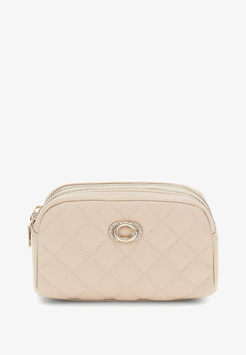 Borsa cosmetica beige trapuntata con logo in metallo dorato. Presenta due zip e una finitura in pelle liscia, con una forma leggermente arrotondata.