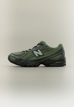 Groene en zwarte New Balance sportschoen met een bovenwerk van mesh en synthetisch materiaal, zwarte veters en een dempende zool met het label "ABZORB".