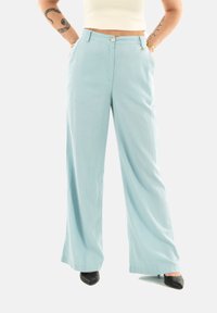 Pantaloni a gamba larga di colore blu chiaro, realizzati in un tessuto morbido. Presentano una chiusura con bottone, tasche frontali e una vestibilità ampia per garantire comfort.