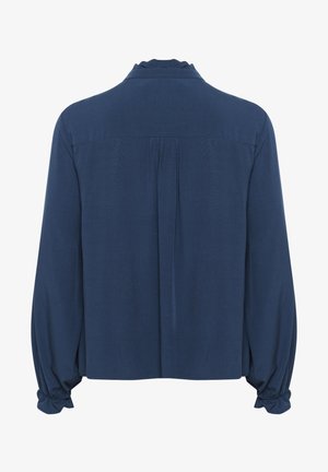 Camicia a maniche lunghe blu navy con colletto volant, chiusura con bottoni sul retro e polsini elastici. Tessuto liscio con una vestibilità leggermente ampia.