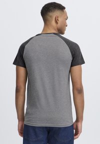 Gray and dark gray short-sleeve t-shirt with a raglan design, featuring a smooth texture and a round neckline, viewed from the back.