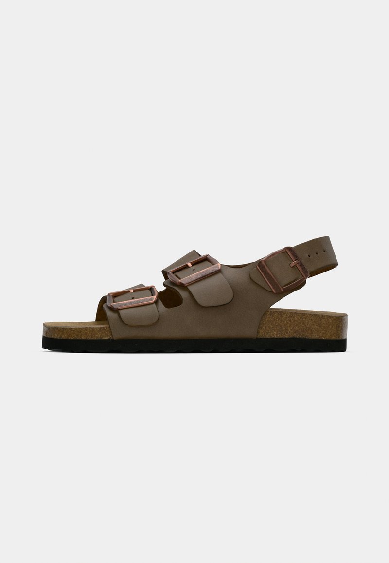 Sandales marron avec deux sangles ajustables, semelle en liège et semelle extérieure en caoutchouc. Comprend des accents de boucles en métal et un design ouvert.