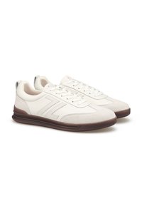 Weiße Leder- und Wildledersneaker mit strukturiertem Finish, ausgestattet mit einer braunen Gummisohle und seitlichem Logodesign. Klassisches Schnürdesign.