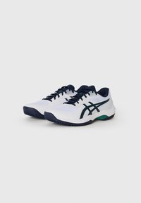 Baskets de sport blanches avec des accents navy, dotées d'un dessus en mesh, d'un système de laçage et d'une semelle en caoutchouc texturé pour l'adhérence.