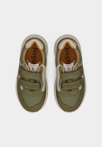 Παιδικά αθλητικά παπούτσια σε ελιά πράσινο και μπεζ με δύο ιμάντες με βέλκρο και μαλακή επένδυση, απεικονιζόμενα από πάνω σε λευκό φόντο.