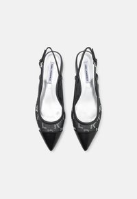 Escarpins slingback noirs à bout pointu, dotés d'une tige texturée avec un motif de logo réfléchissant et une doublure argentée.