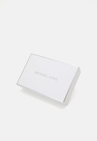 Vit rektangulär korthållare med silverkanter, med präglad "MICHAEL KORS"-logotyp på framsidan i en minimalistisk design.