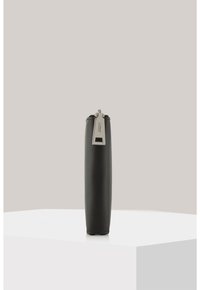 Black leather pencil case with a smooth texture, slim cylindrical shape, silver zipper hardware, and a subtle brand tag detail.