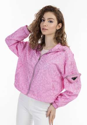 Giacca rosa corta con un motivo geometrico, chiusura con zip, cappuccio e una tasca con zip sulla manica con un'accento triangolare.