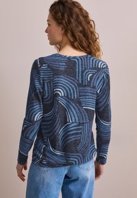Langärmliges Oberteil mit navy- und blauen Wirbelmustern, aus einem strukturierten Strickstoff gefertigt, mit einem gerundeten Halsausschnitt und lockerem Schnitt.