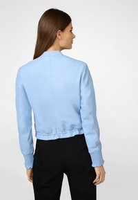 Hellblaues Bomberjacke mit schlanker Passform, gerippten Bündchen und gerafftem Saum. Hergestellt aus glattem Material, Rückansicht ohne zusätzliche Details gezeigt.