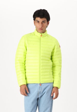 Jachetă puf lime cu un design matlasat vertical, guler înalt și fermoar complet. Prezintă un sistem de prindere portocalie și un stil minimalistic.