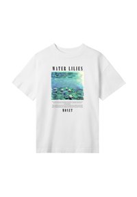 Hvid bomulds T-shirt med et trykt "Vandliljer" kunstværk af Monet, med sort tekst over og under grafikken. Korte ærmer, afslappet pasform.