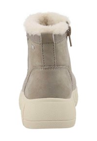 Taupe suede enkelboot met een fluffy beige bontkraag. Voorzien van een sluiting met een ritssluiting aan de achterkant en een gestructureerde rubberen zool.