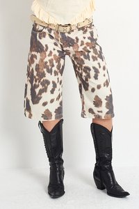 Krátké kalhoty culotte v leopardím vzoru v béžové a hnědé barevné kombinaci, doplněné černými koženými kovbojskými botami se švy.