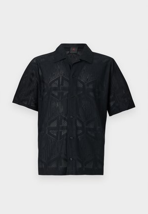 Maglietta nera a maniche corte con un motivo geometrico e diverse texture. Ha una chiusura con bottoni sul davanti e un design del colletto classico.