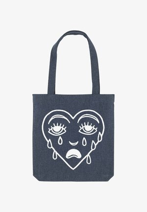 Denim boodschappentas met een groot wit geborduurd hartdesign met verdrietige ogen en tranen, dat contrasteert met de donkerblauwe stof.