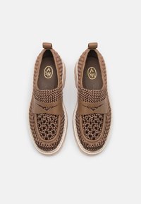 Baskets tressées marron avec une sangle en cuir lisse. Elles présentent un dessus texturé et tressé ainsi qu'une semelle rembourrée. Design à bout rond.