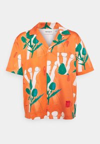 Pomarańczowa bawełniana koszula z krótkim rękawem i zapinana na guziki, z wyrazistym botanicznym wzorem w zielone i białe elementy. Posiada kieszeń na piersi.