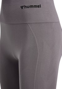 Grå leggings med teksturerede paneler med chevronmønster, en bred talje med præget Hummel-logo og en glat stoffinish.