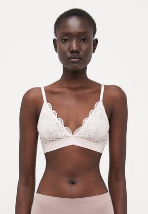 Lace bralette in light beige with a triangular shape, scalloped edges, and thin straps. Soft fabric with a smooth underband.