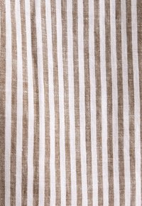 Tissu blanc avec des rayures verticales beige espacées régulièrement créant un motif simple et texturé.