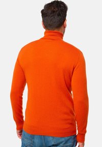 Oranger Rollkragenpullover aus weichem Material, mit figurbetontem Schnitt und gerippten Bündchen. Die Rückansicht zeigt eine glatte Textur ohne Verzierungen.