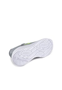 Gray athletic shoe with a white rubber outsole, textured grip, and a vibrant green logo accent on the side.