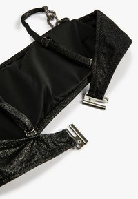 Schwarzer BH mit glänzenden schwarzen Akzenten, verstellbaren Trägern, Metallbeschlägen und einem glatten Innenstoff. Auffällig durch sein elegantes Design.