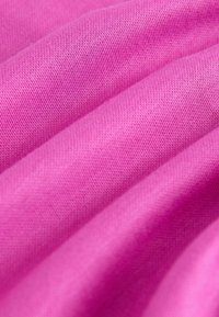 Textures de tissu rose avec une surface lisse, présentant des plis et un léger motif d'étirement. La couleur est vive et uniforme partout.