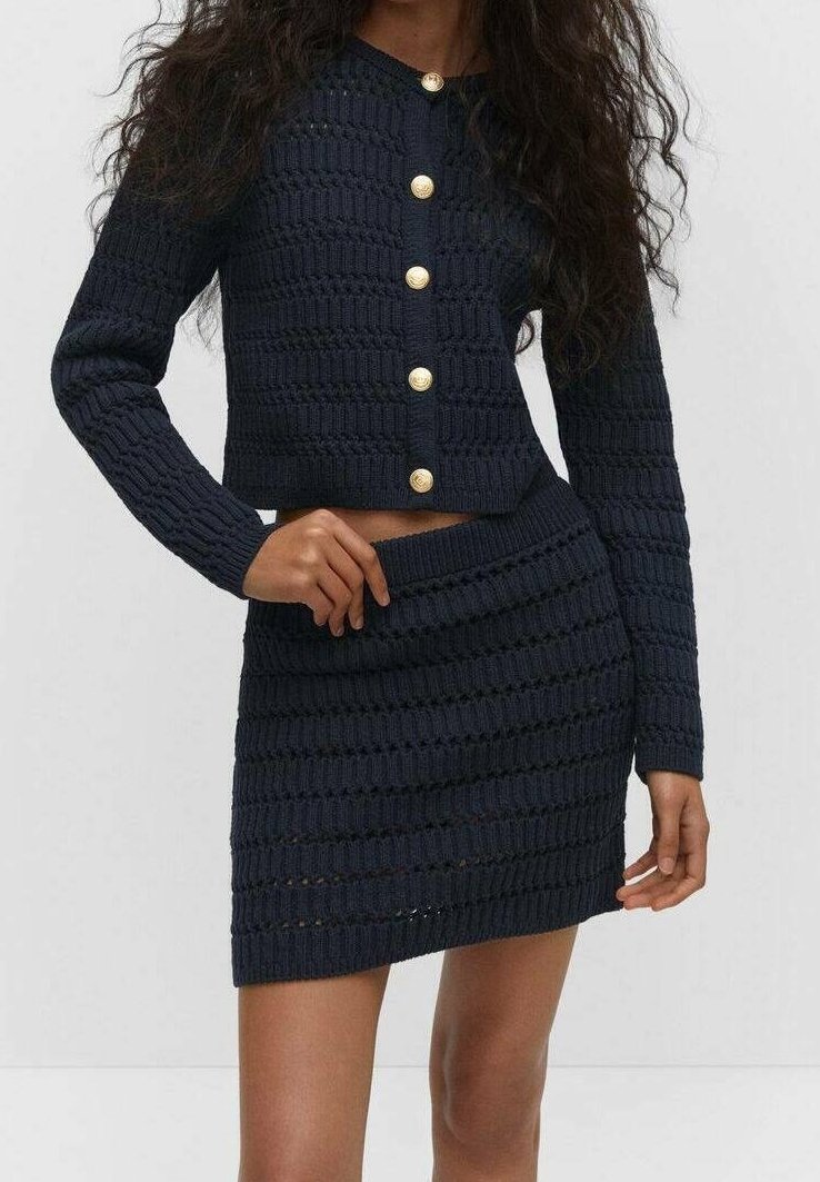 Ensemble en deux pièces tricoté bleu marine, comprenant un cardigan court avec cinq boutons dorés et une jupe slim avec un motif texturé.
