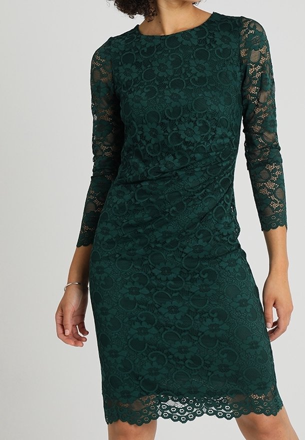 Robe en dentelle vert émeraude avec manches trois-quarts, motifs floraux, ourlet festonné et silhouette ajustée. Texture de tissu lisse sur toute la surface.